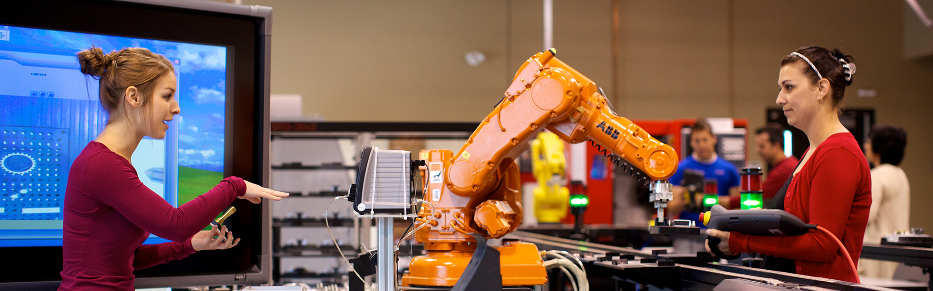 Étudiante manipulant un bras robotique automatisé dans un laboratoire du programme technologie de l’électronique industrielle