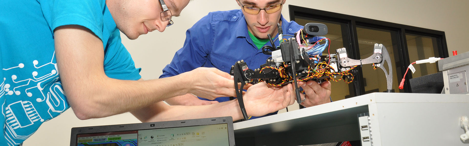 Étudiants du programme Systèmes Ordinés qui manipulent un robot